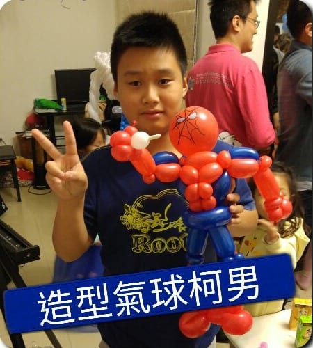 男孩比 YA 拿著紅藍色蜘蛛人造型氣球