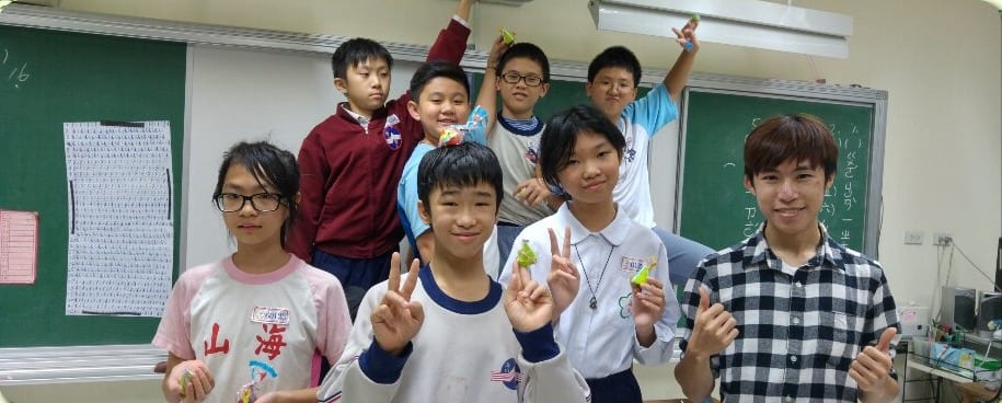 穿格子襯衫的我和海山國小小朋友在黑板前合照