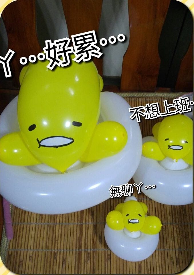 大中小三種尺寸的蛋黃哥造型氣球,趴在白色蛋白上