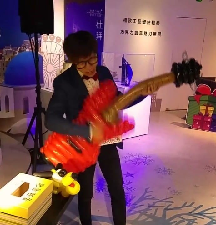 淡水巧克力夢公園舞台上，柯男抱著紅色氣球電吉他表演