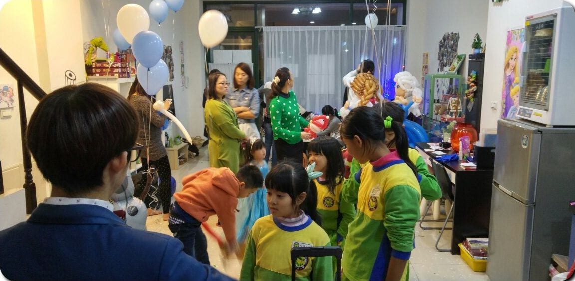 一群穿黃綠色運動服的孩子圍在折氣球的我身邊