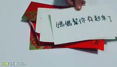 手寫字卡「媽媽幫你存起來了」壓在一疊紅包上
