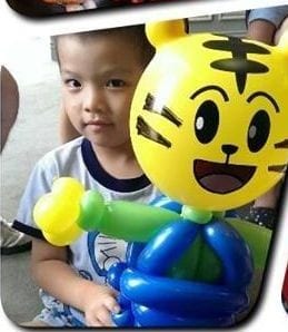 小男孩和黃色老虎臉的巧虎造型氣球合照