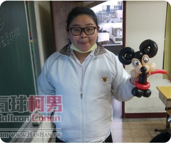 靜修女中氣球課，學生在黑板旁拿著自己折的米奇造型氣球