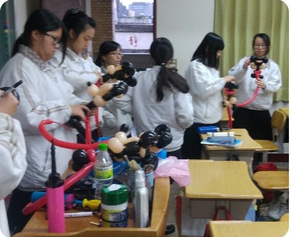 靜修女中教室裡，學生們拿著打氣筒和氣球練習折米奇