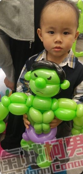 精品婦幼用品店開幕，男孩抱著綠色浩克造型氣球