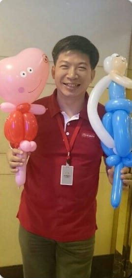穿紅色上衣的工作人員拿著佩佩豬和公主造型氣球