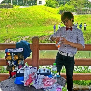 親水公園木欄杆旁的折氣球定點，後方是草坡和健走的人