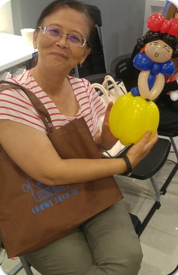 女士坐著拿白雪公主造型氣球，銀行營業大廳