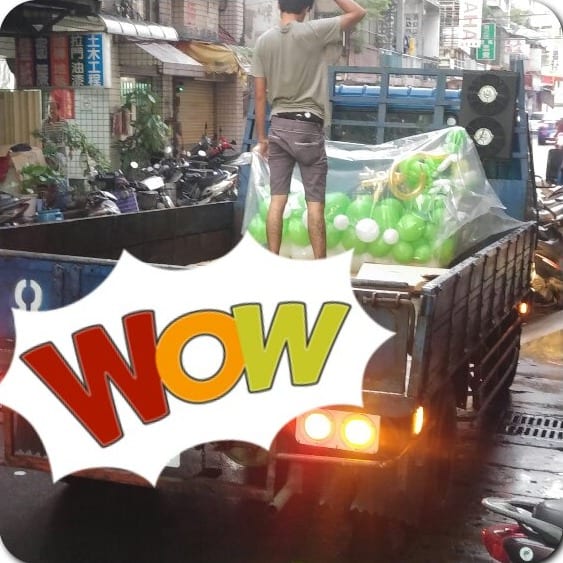 貨車車斗上用透明袋包好的綠色氣球龍舟