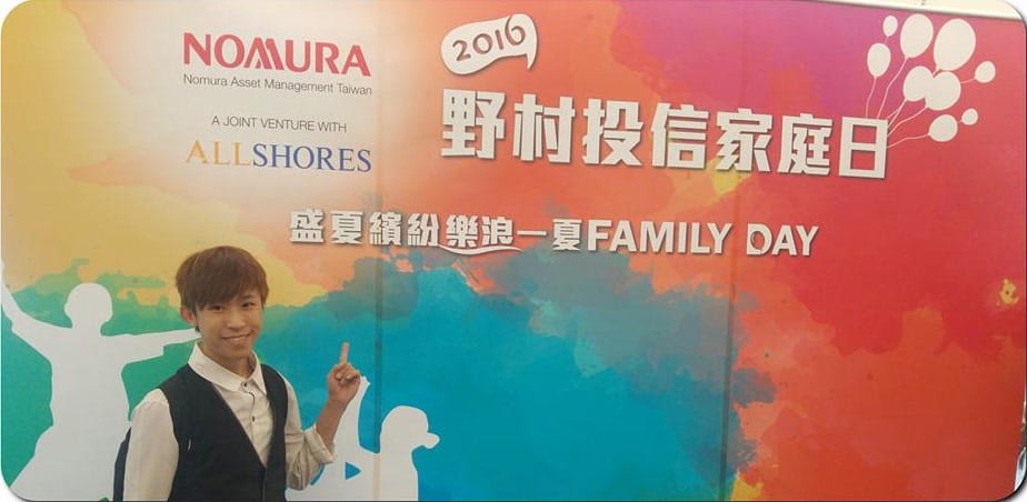 台北 101 野村投信家庭日活動背板前,我比著背板合照