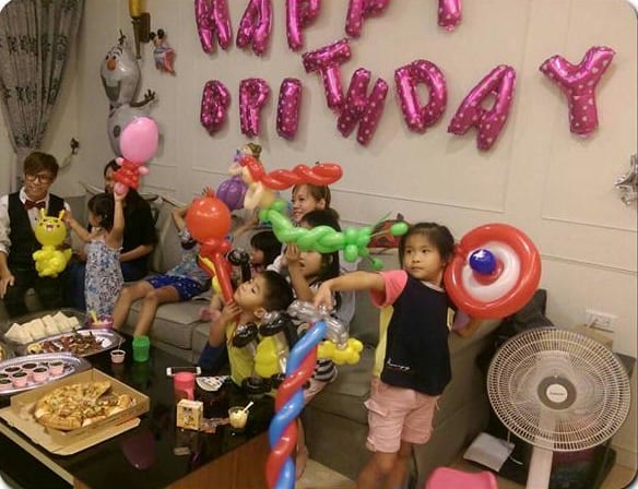 淡水居家生日派對客廳，HAPPY BIRTHDAY 字母氣球下拿著造型氣球的小朋友
