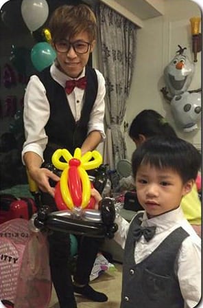 我把機車造型氣球交給穿背心打領結的小男孩