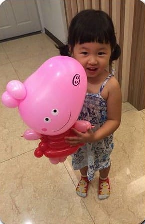 淡水生日派對上，綁辮子的小女孩抱著粉紅色佩佩豬造型氣球