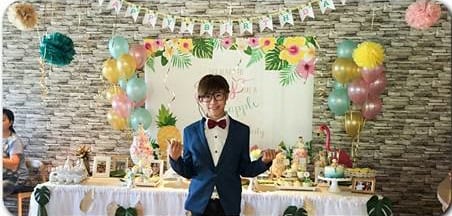 熱帶風生日甜點桌，兩側粉紅、粉藍、金色氣球串