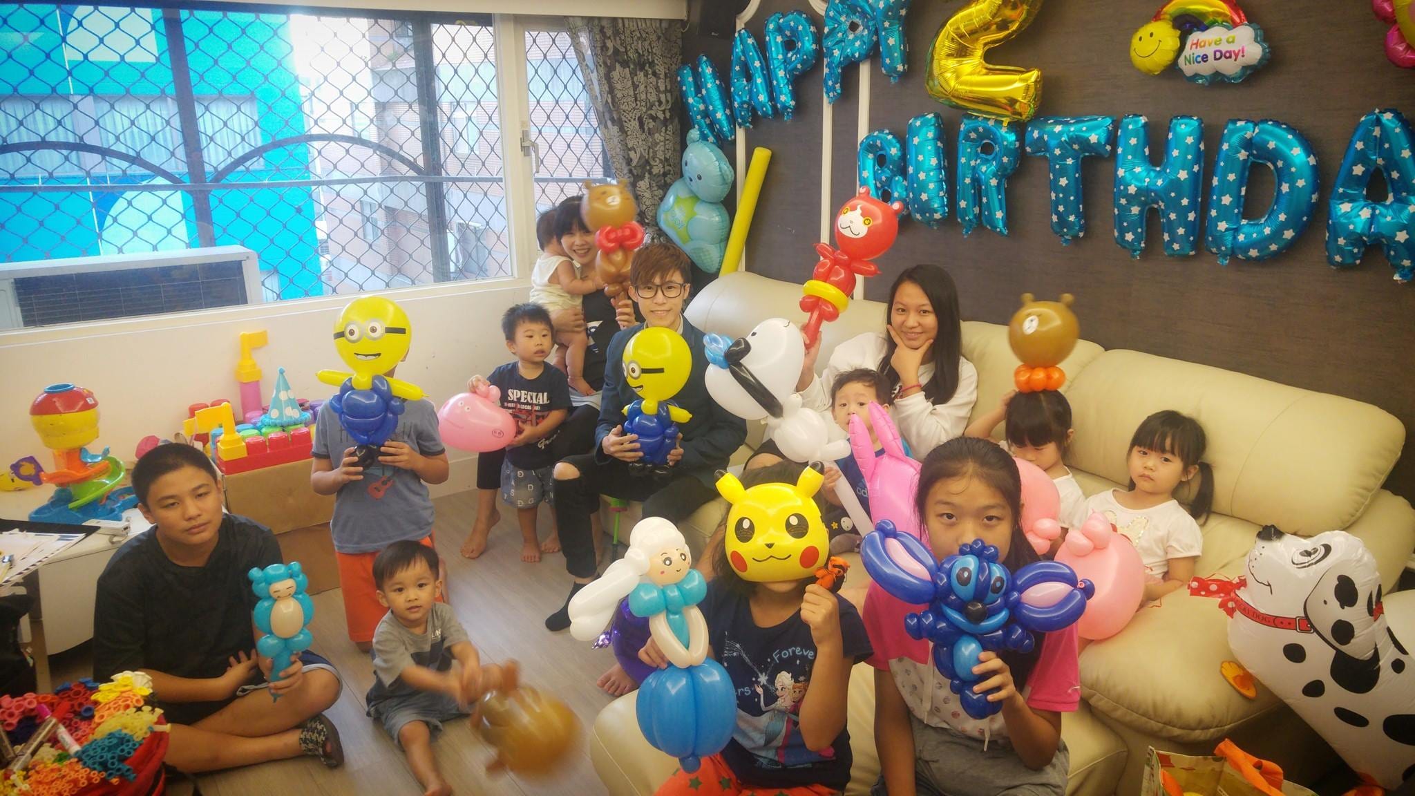 兩歲居家生日派對，小朋友拿著吉胖喵、小小兵、皮卡丘等造型氣球在沙發前合照