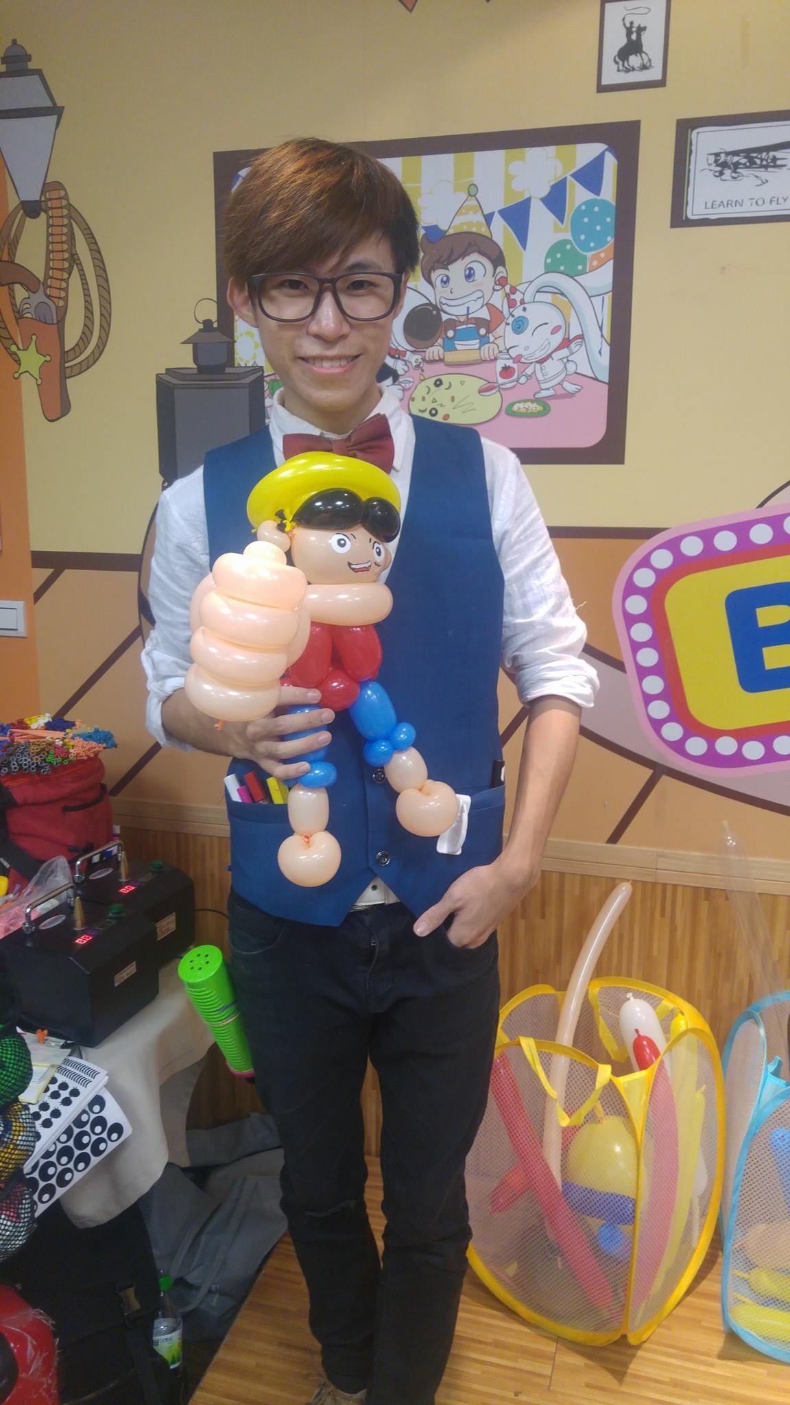 柯男抱著戴草帽、伸出大拳頭的魯夫造型氣球站在牛仔風彩繪牆前