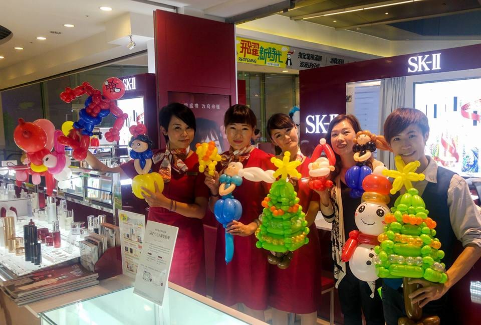 台中新時代購物中心 SK-II 專櫃，櫃姐與柯男拿著聖誕樹、雪人造型氣球合照