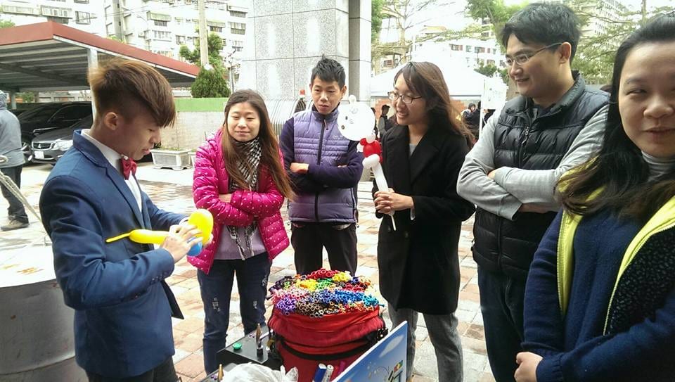 桃園「道平人愛行」活動戶外折氣球，民眾在攤位前排隊等氣球