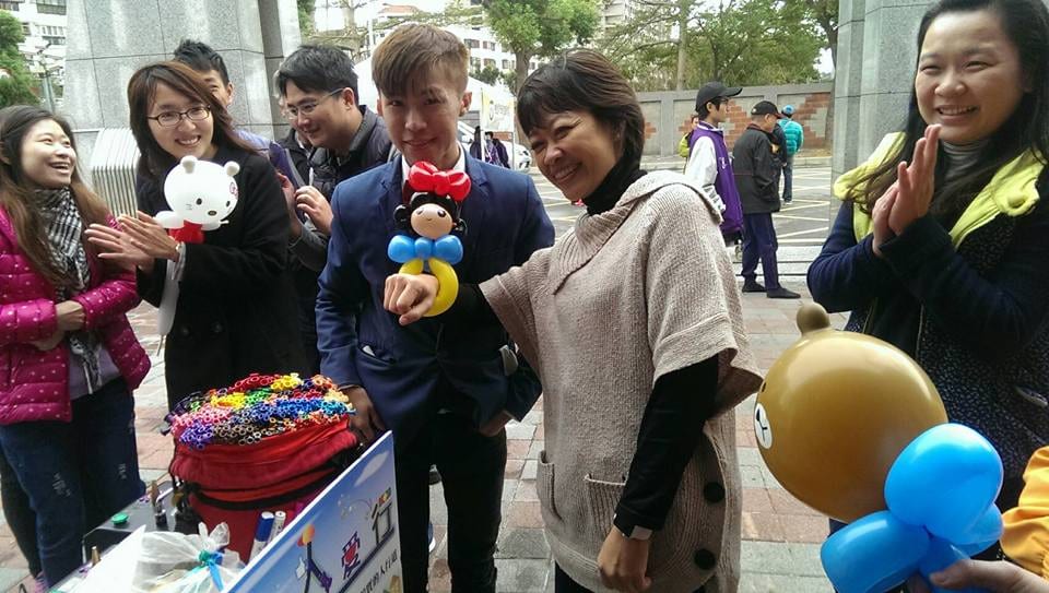 「道平人愛行」活動折氣球攤位，民眾拿著白色小熊與咖啡色小熊造型氣球