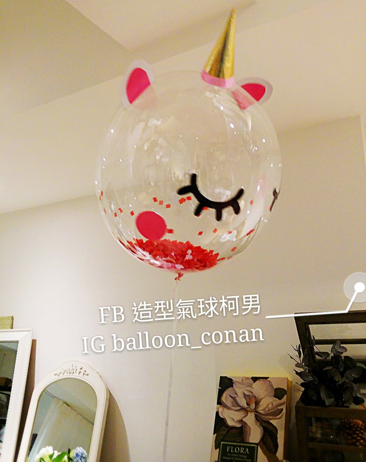 獨角獸臉透明波波球，金色獨角、粉紅耳朵、黑色閉眼睫毛，球內底部裝滿紅色亮片