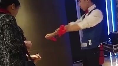 EPSON 尾牙花絮影片畫面，柯男拿著紅色道具和賓客近距離魔術互動