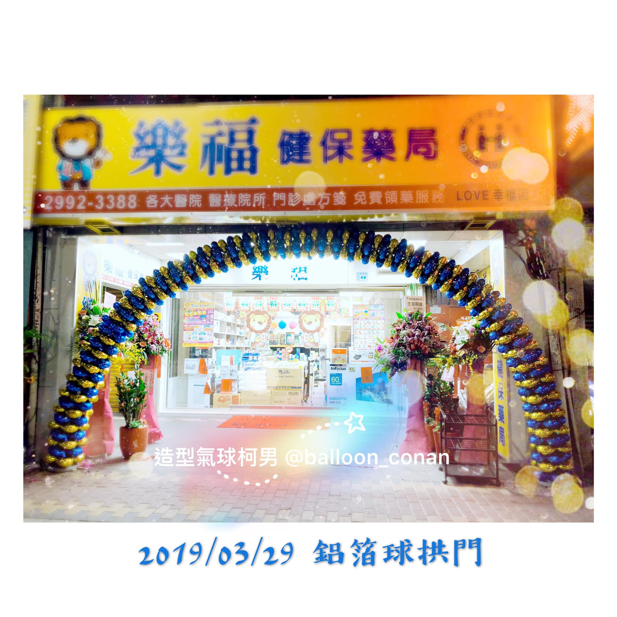 樂福健保藥局店門口的深藍與金色螺旋鋁箔氣球拱門，兩側擺著祝賀花籃
