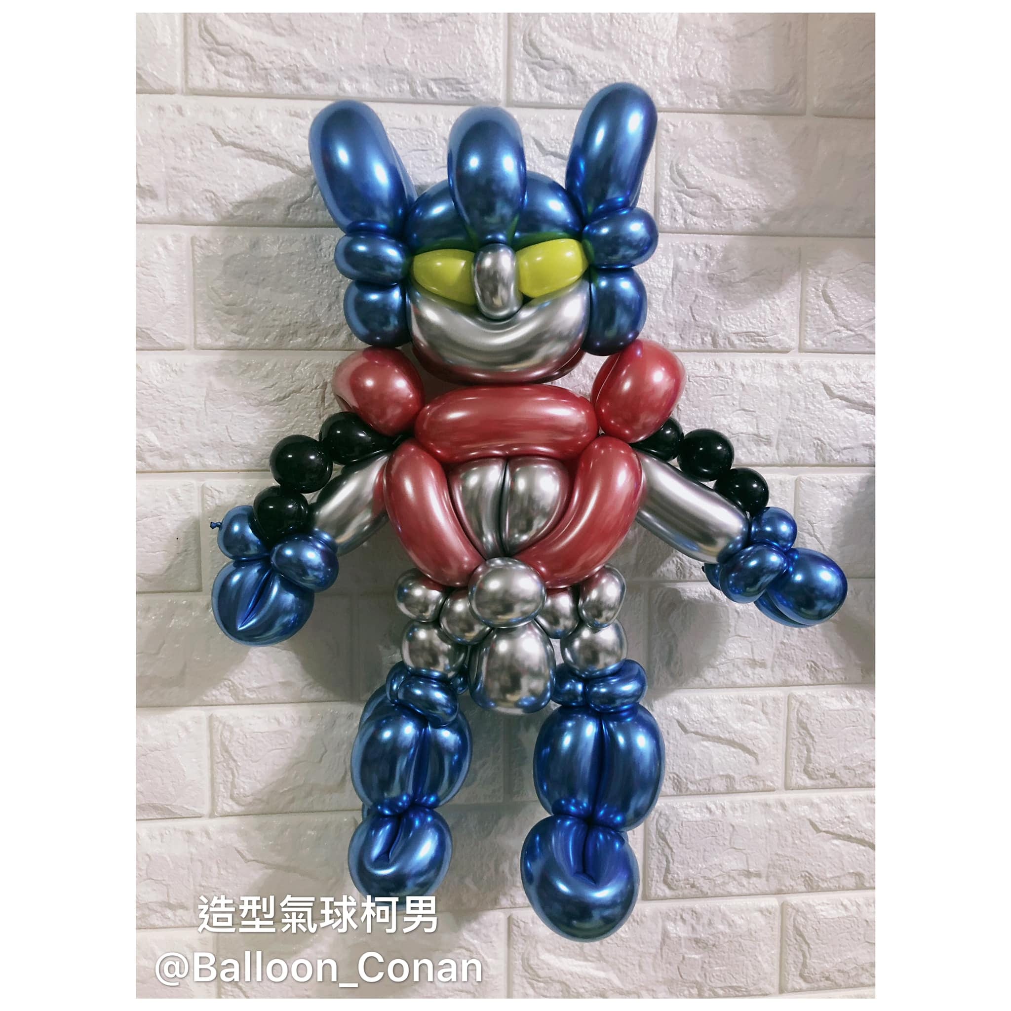 金屬藍、紅、銀配色的柯博文造型氣球，貼在白色磚牆上