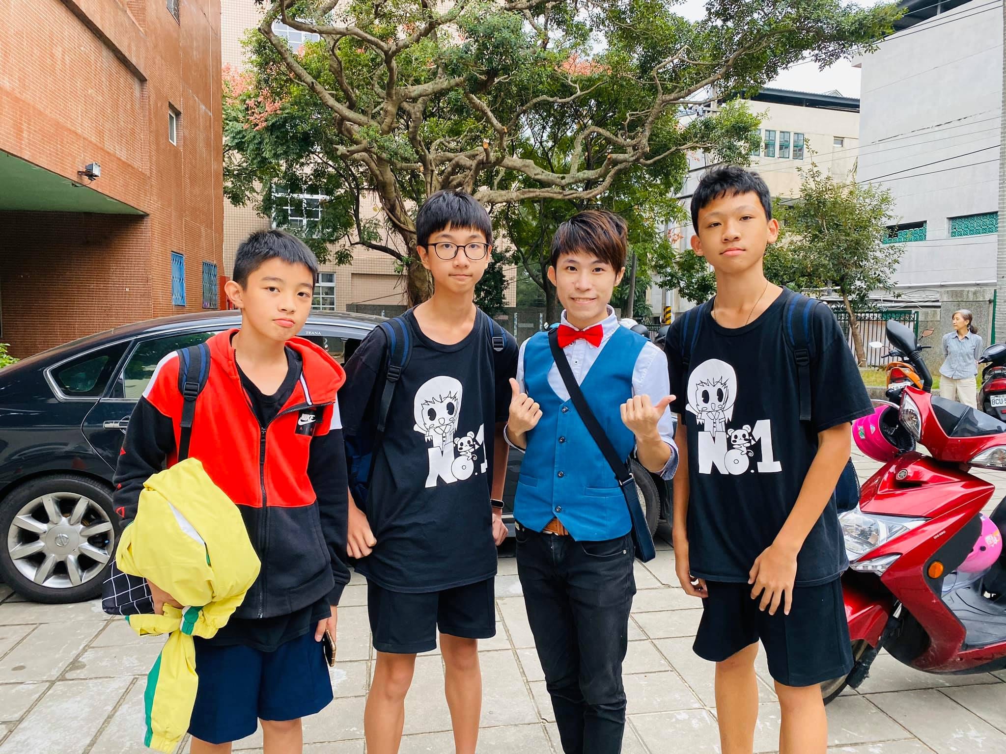 三位男同學和講者在淡水國中校園戶外合照