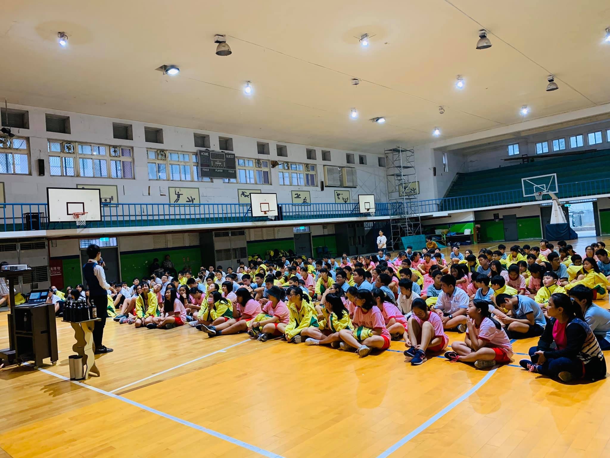 淡水國中體育館內,七年級學生坐在木地板上等待演講開始