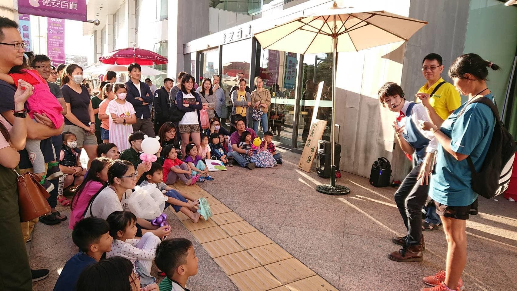 台南德安百貨門口,孩子們坐在地上看表演,我和小幫手在前方