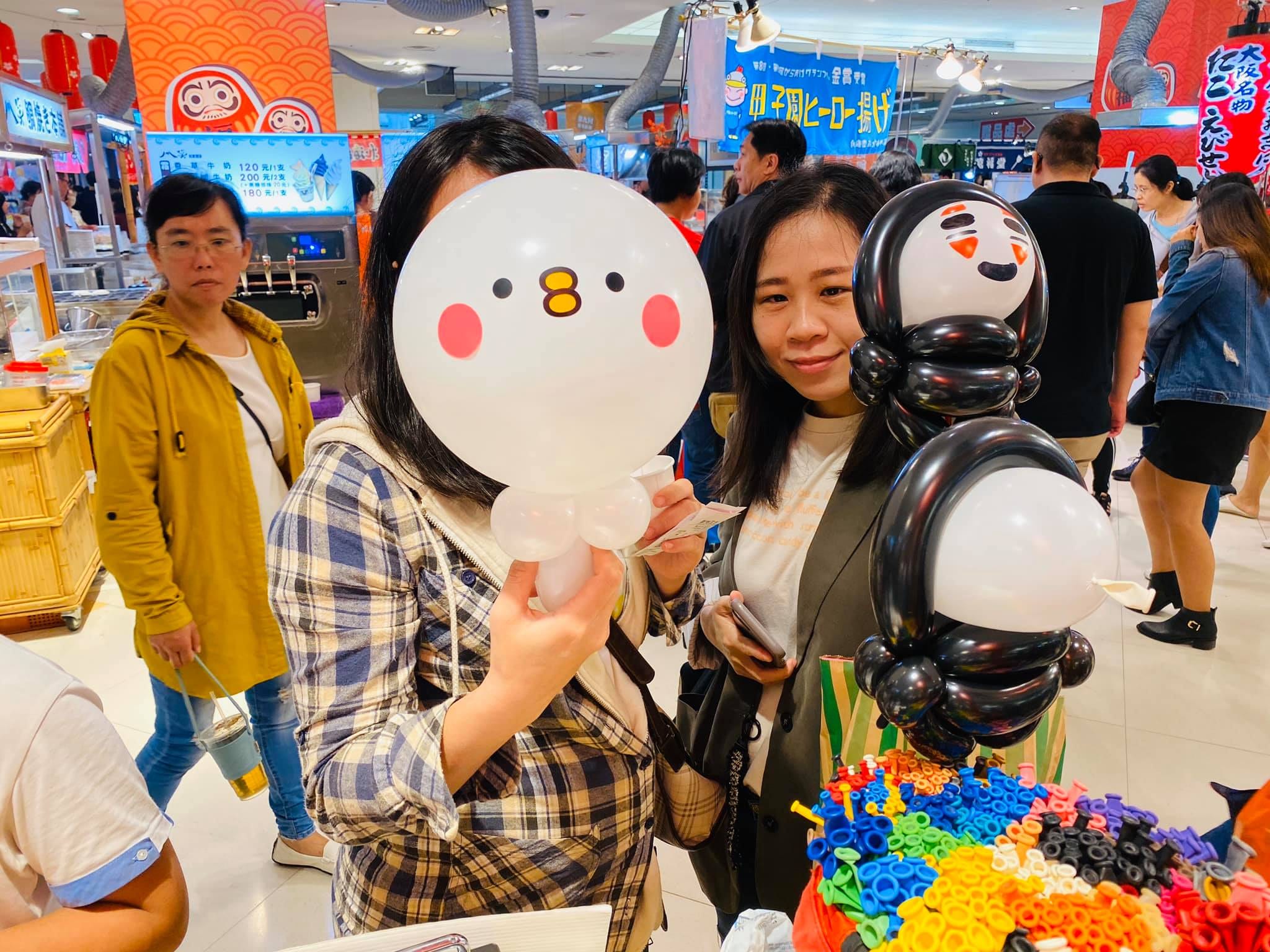 兩位媽媽拿著白色小鳥與黑白企鵝手持棒