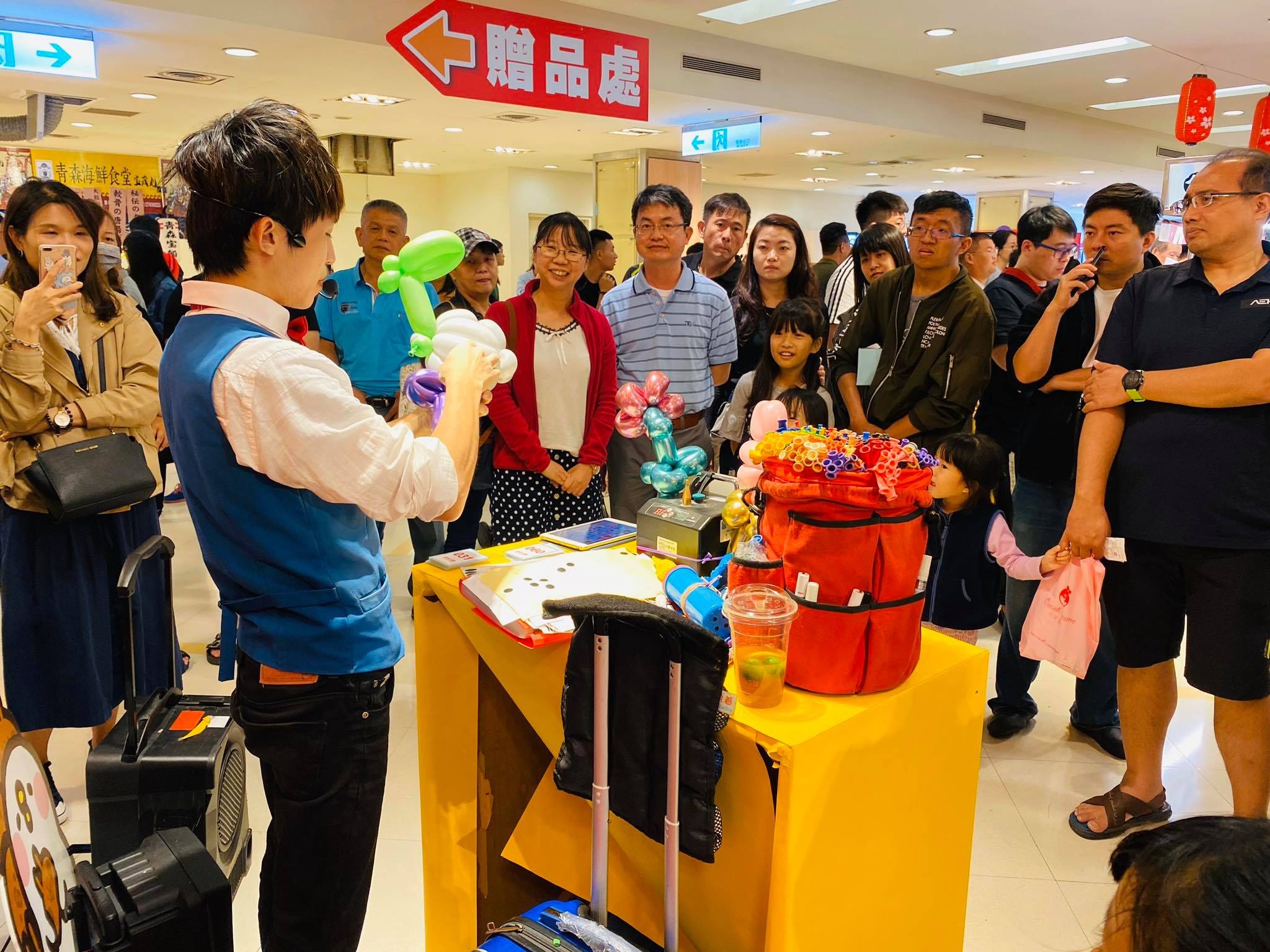 日本展贈品處前,大人小孩圍著看我折氣球