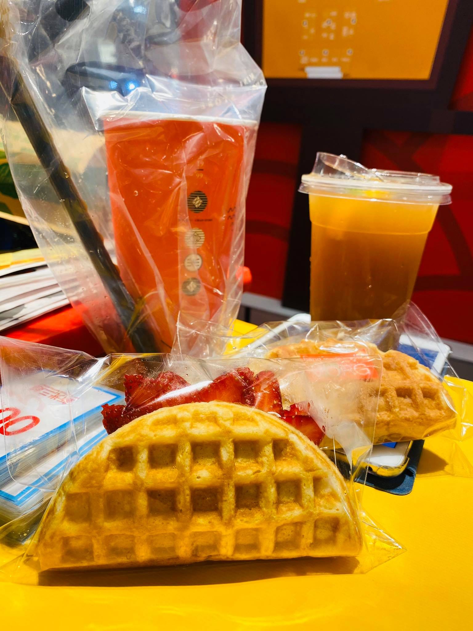 攤位桌上的鬆餅、草莓與兩杯飲料