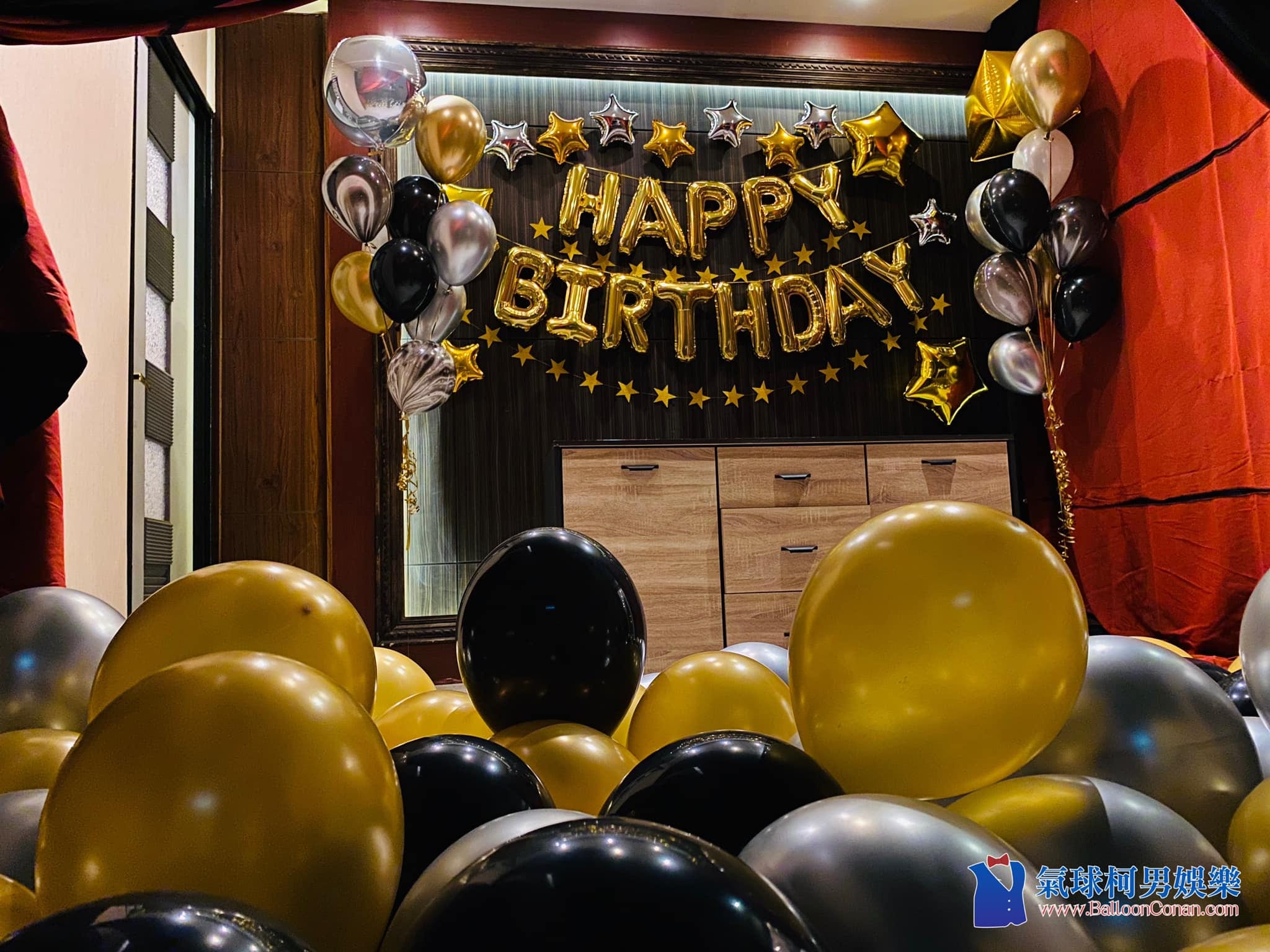 炮仔聲生日場景，深色木牆上的金色 HAPPY BIRTHDAY 字母與黑金銀氣球