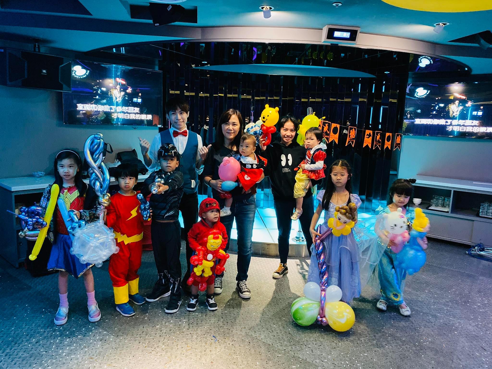 錢櫃 KTV 總統包廂裡,穿英雄與公主服裝的孩子們拿著造型氣球合照