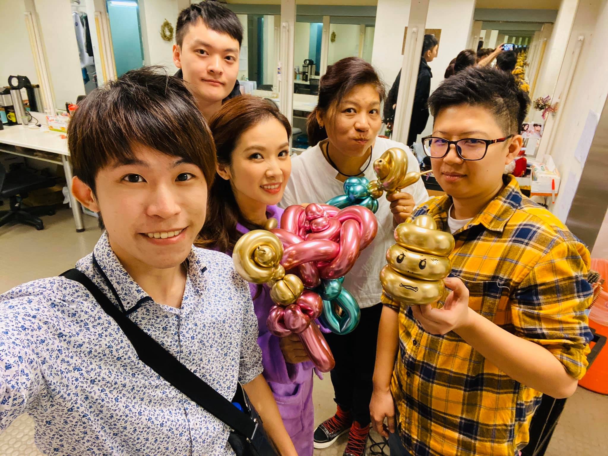 化妝間裡我和劇組演員們自拍，有人拿著粉紫玫瑰與金色造型氣球