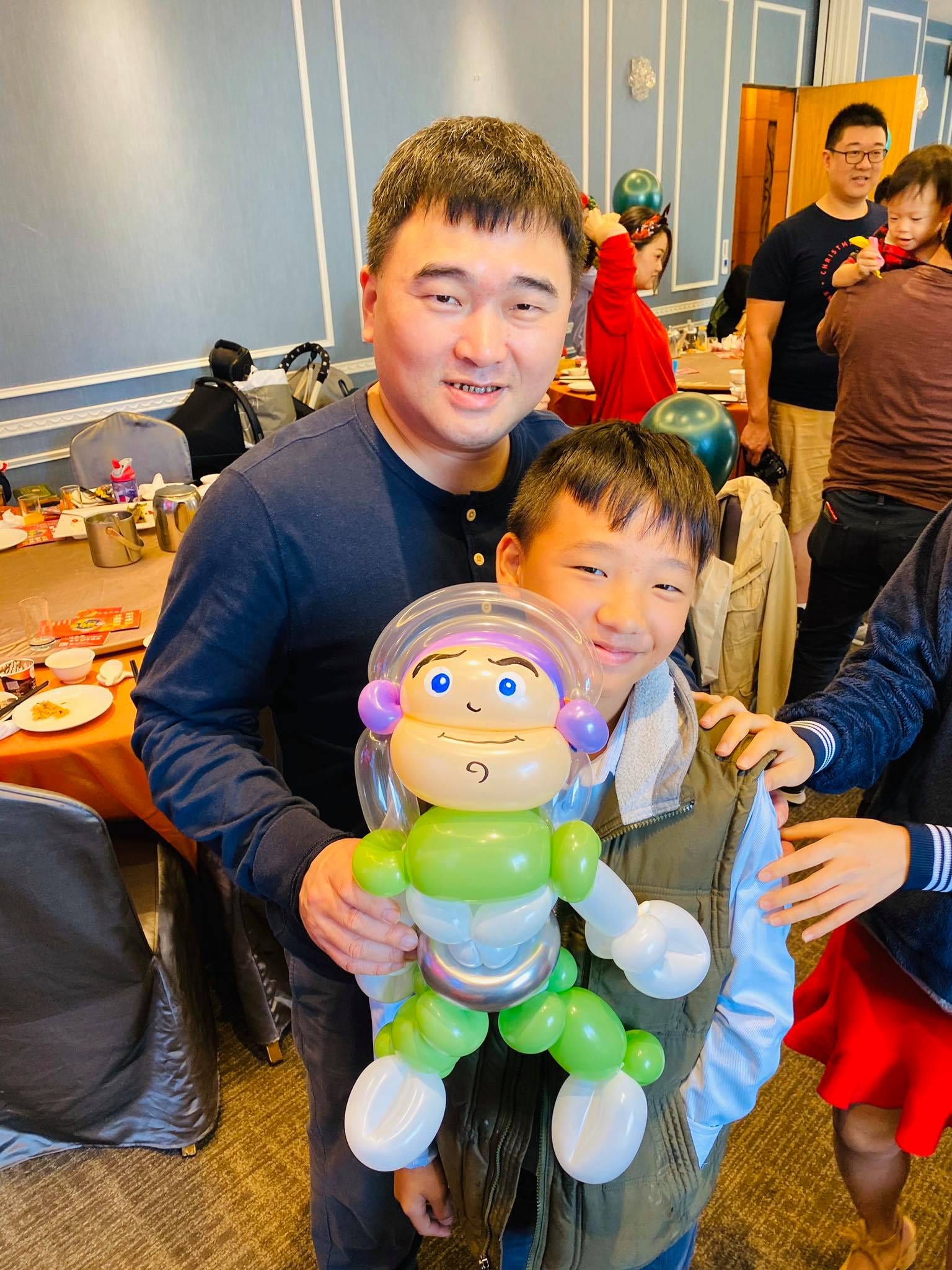 爸爸和兒子拿著綠白色巴斯光年全身造型氣球