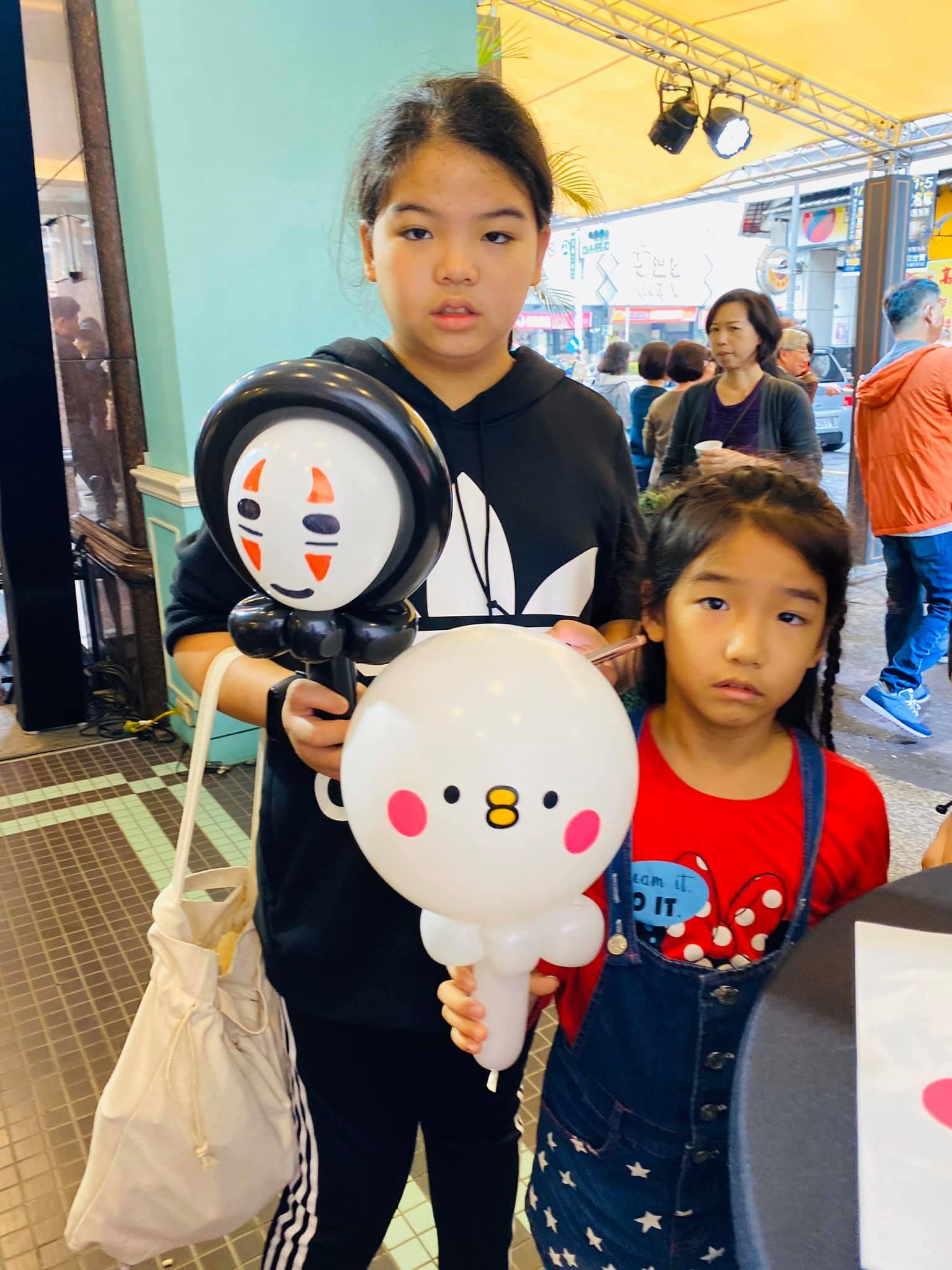 姊妹倆拿著無臉男和白色圓臉小雞氣球
