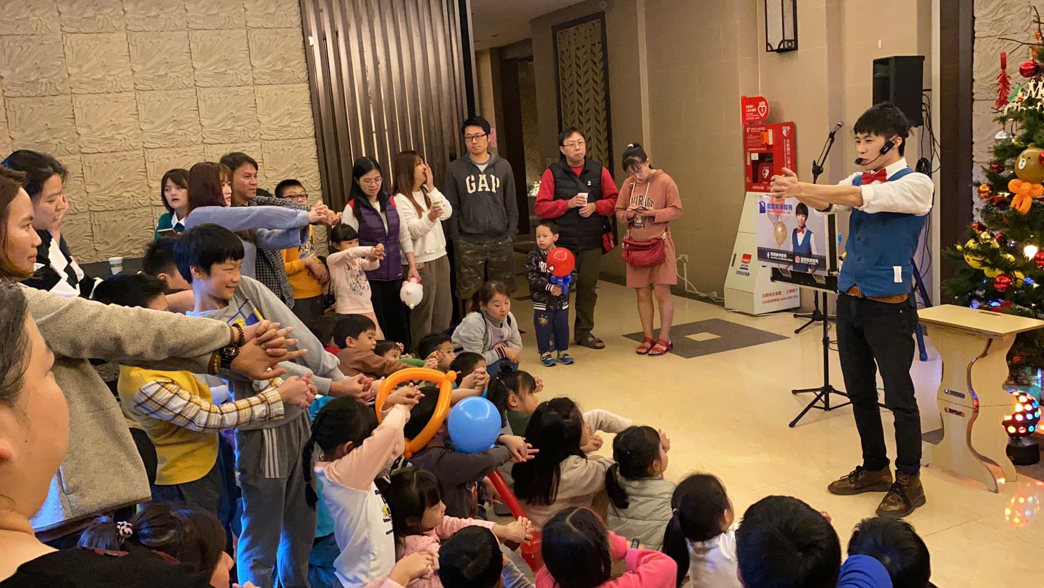 魔術表演中，台下大人小孩一起伸出手跟著做動作