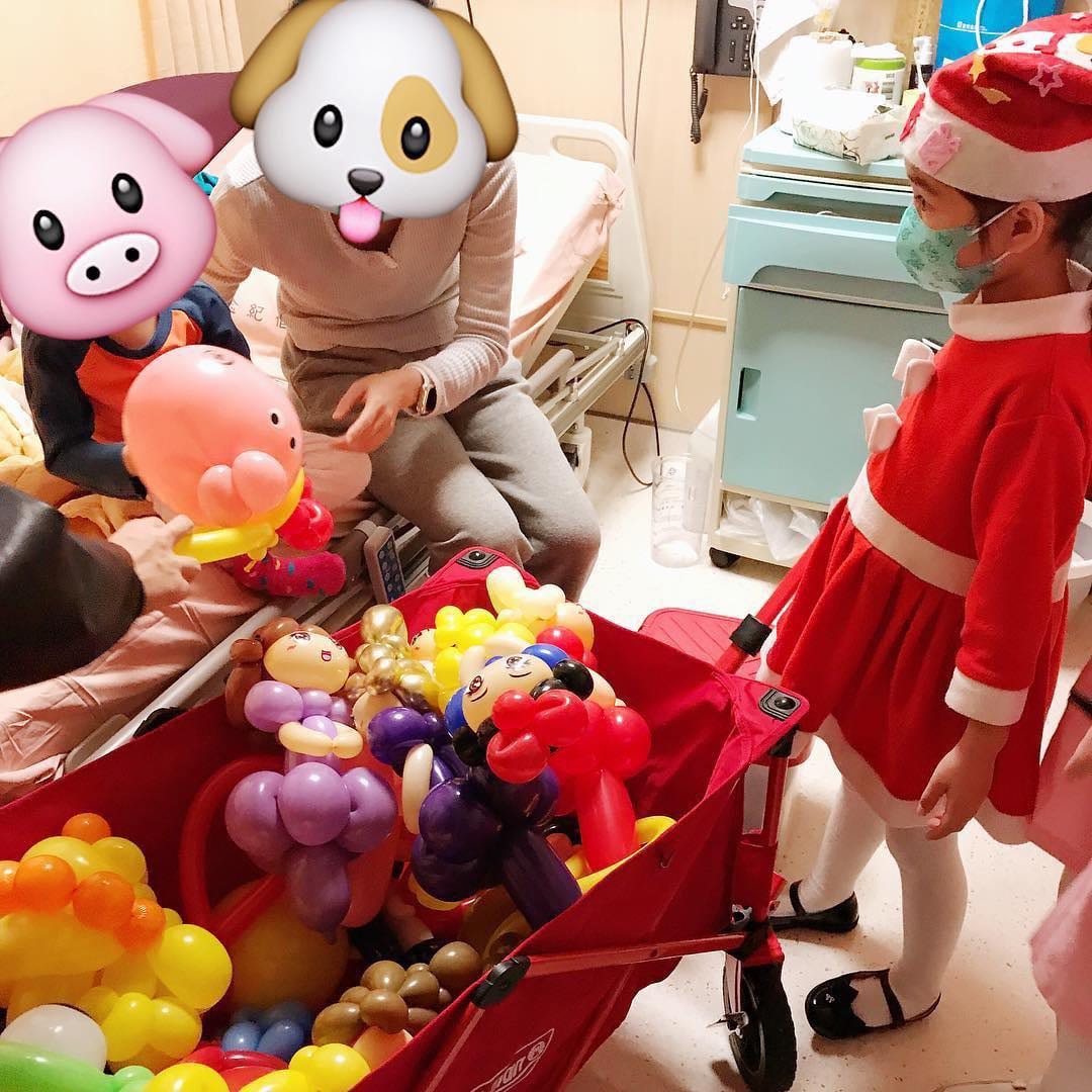 聖誕裝女孩在病床邊遞出氣球，臉部以表情貼圖遮住