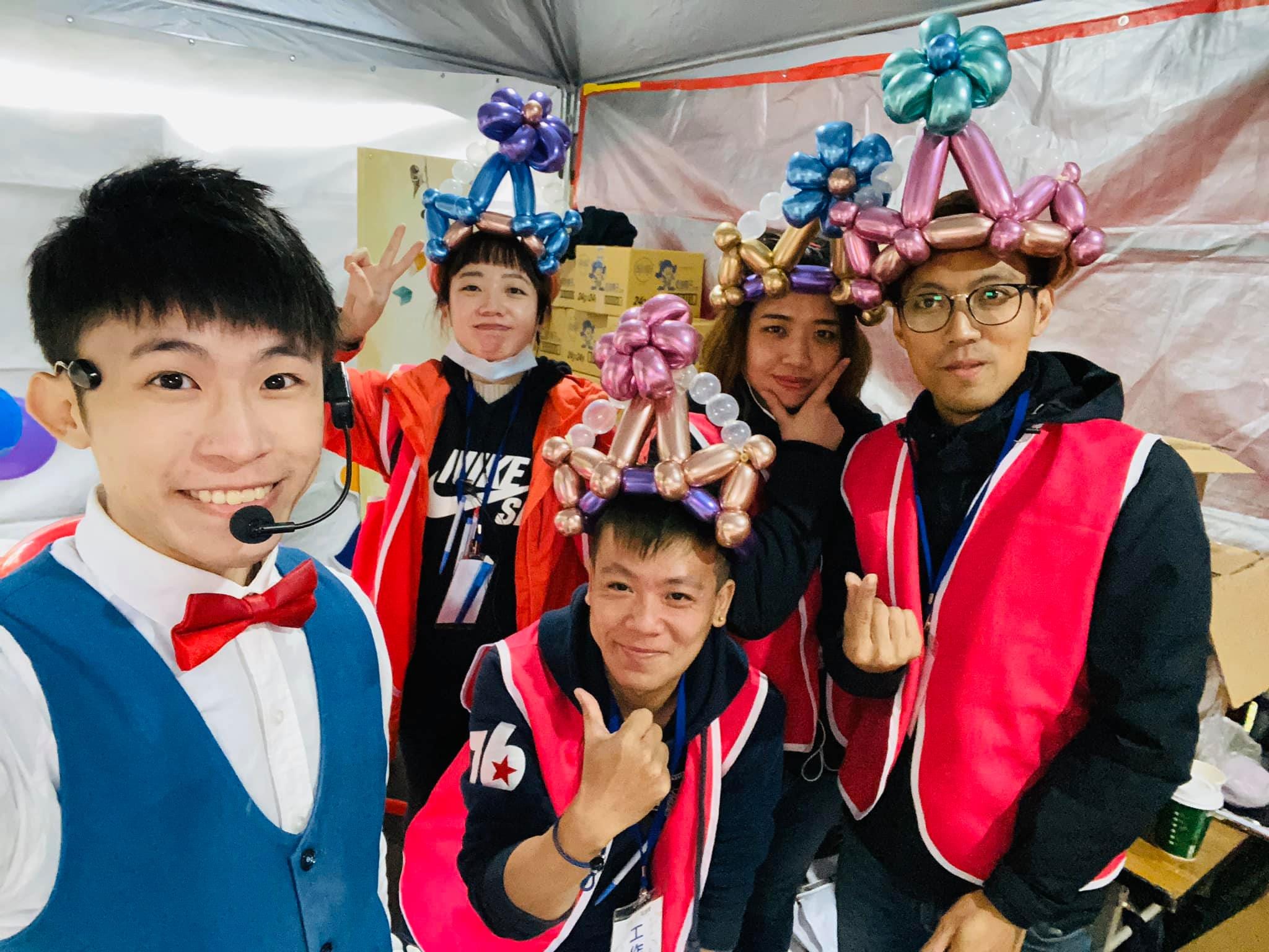 我和戴著彩色氣球皇冠的工作人員們在帳篷裡自拍