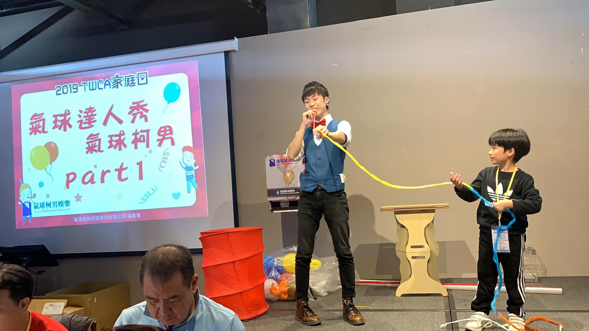 宜蘭傳藝中心 TWCA 家庭日舞台，投影寫著氣球達人秀，我和小男孩拉長條氣球