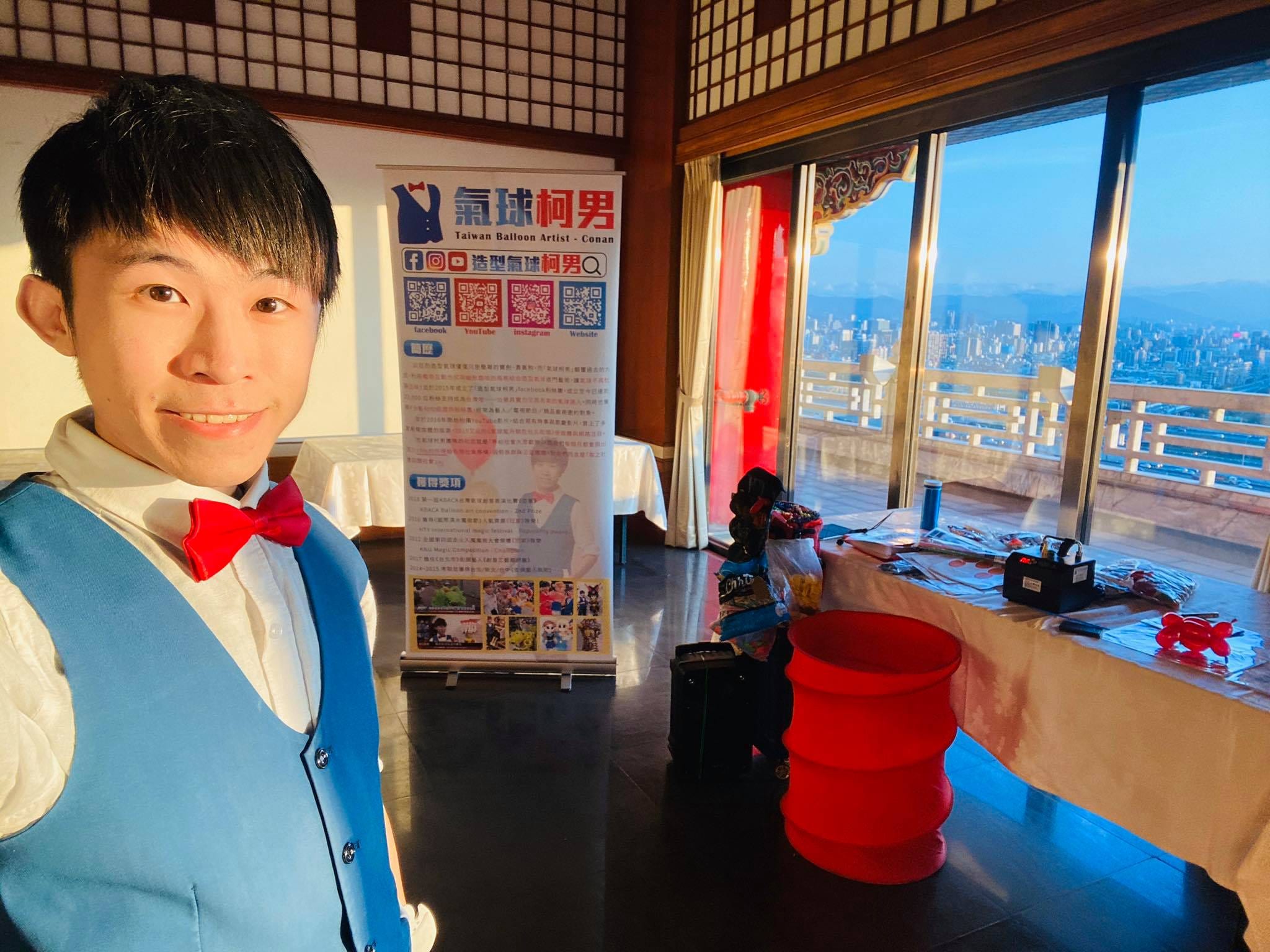 高樓宴會廳窗邊的折氣球攤位，我在立牌前自拍