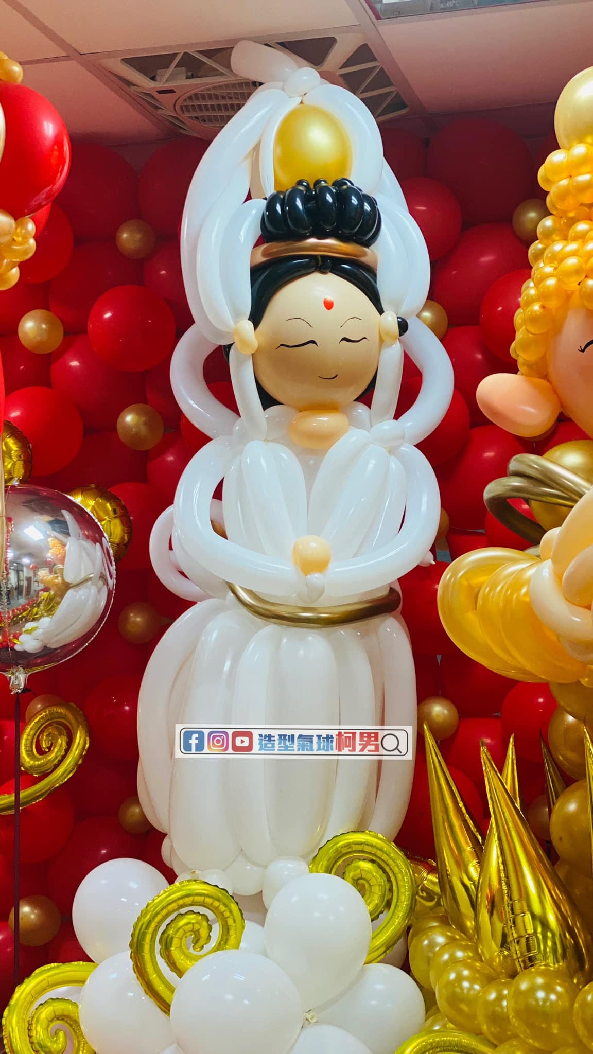 白色長袍、金色頭飾的觀音氣球人偶特寫,腳下是白色雲朵