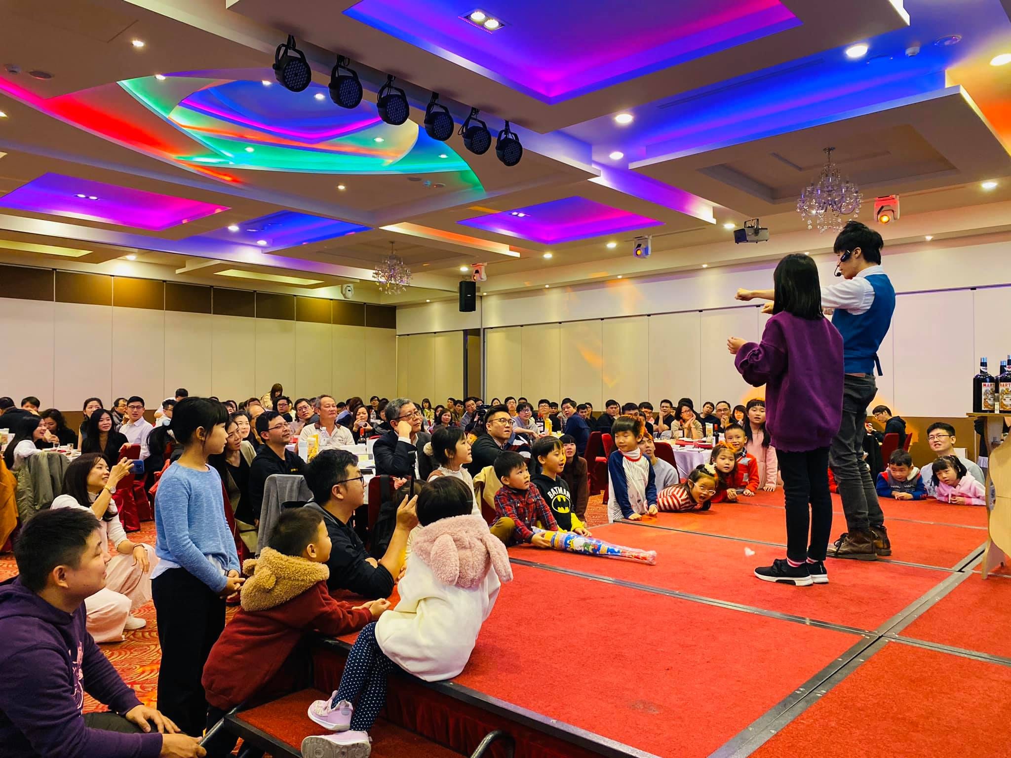 尾牙宴會廳裡，我和上台的小女孩一起表演，台下坐滿員工