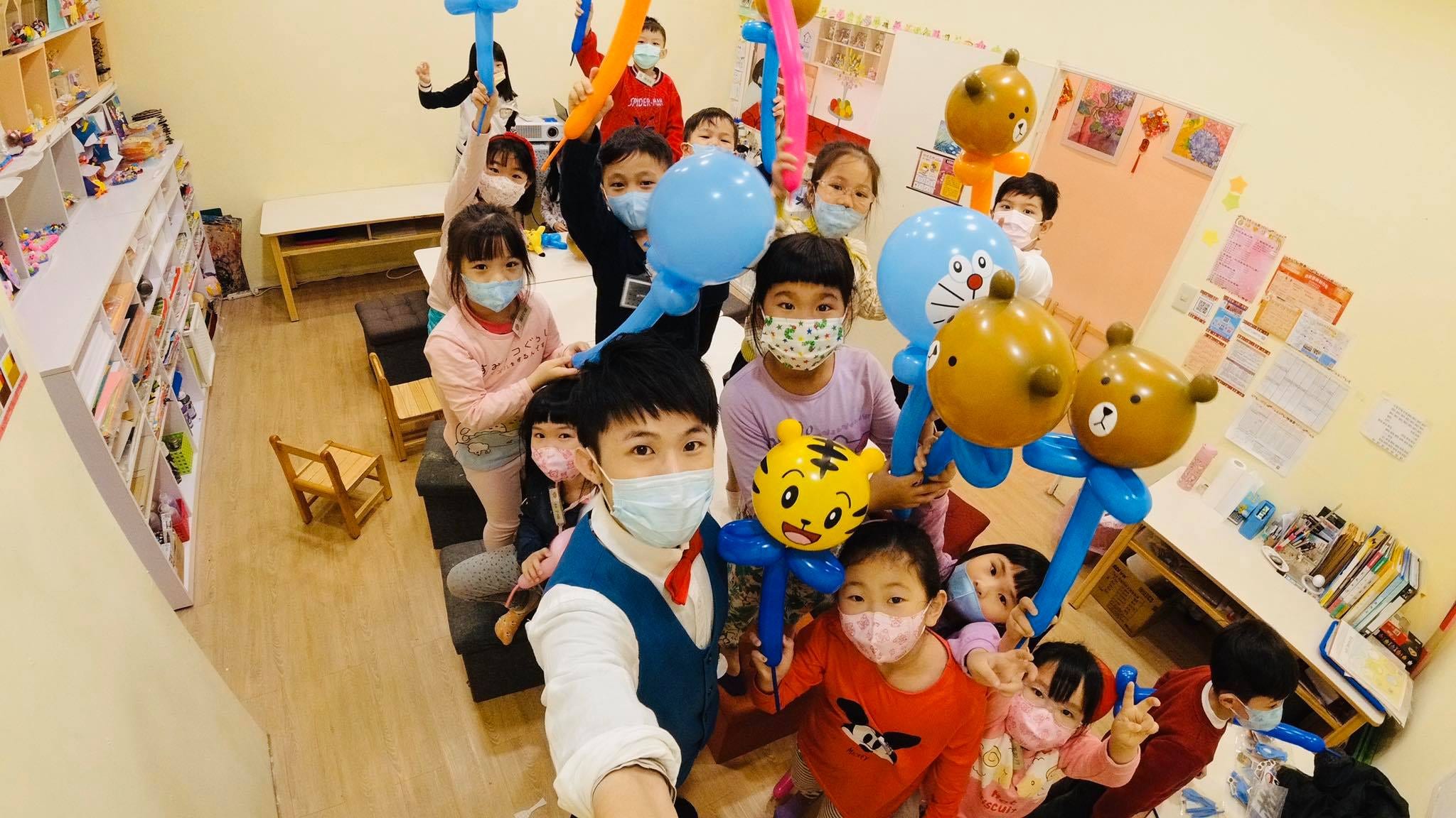 教室裡由上往下的自拍,孩子們圍著我舉起自己完成的造型氣球