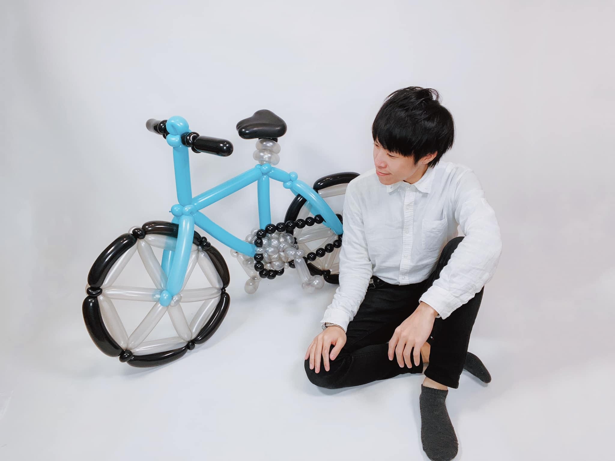 4 月初作品照：淺藍車架、黑白車輪的氣球腳踏車，我坐在旁邊