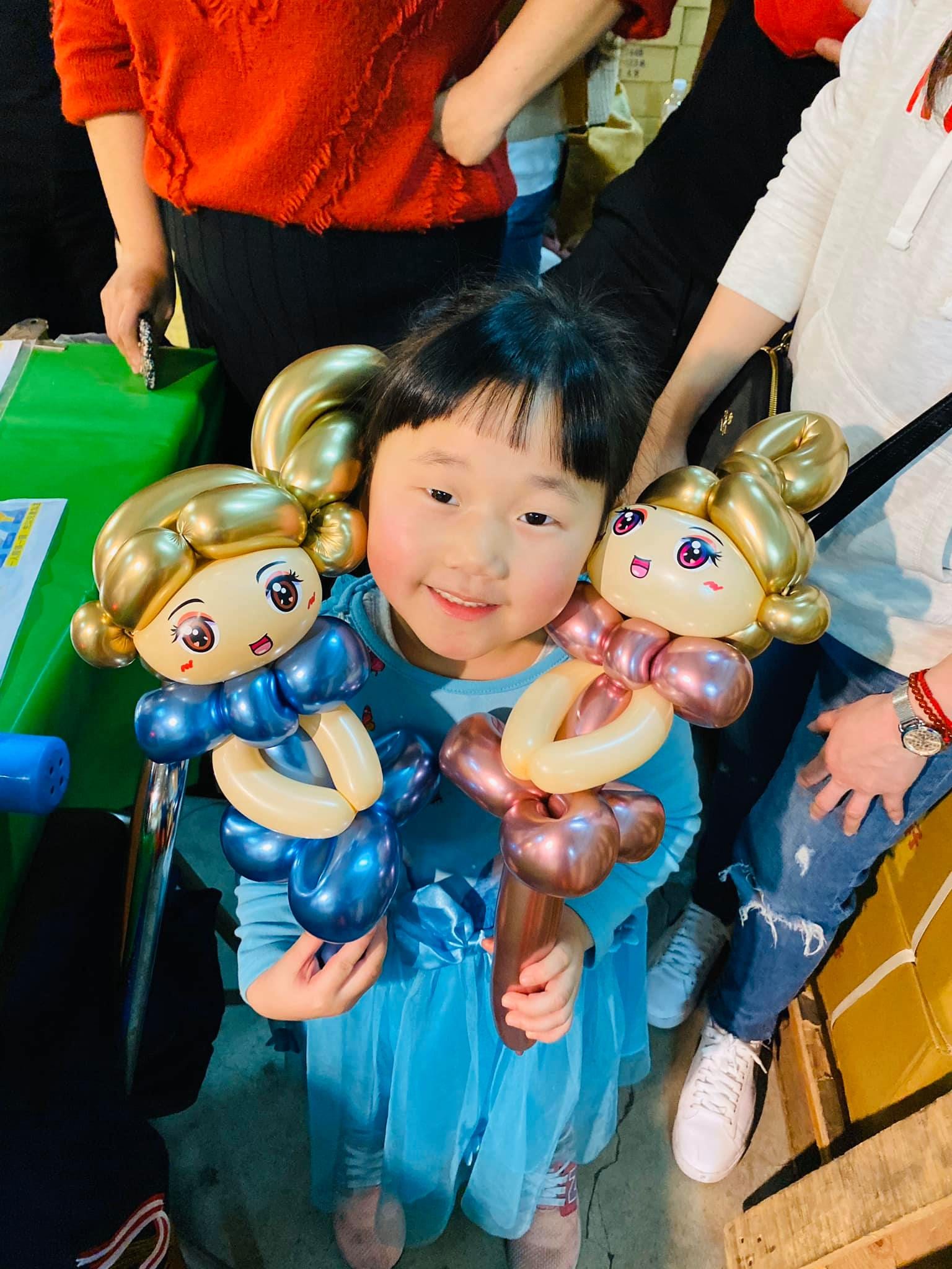 藍色紗裙女孩左右各抱一隻金髮公主，分別是金屬藍與玫瑰金禮服