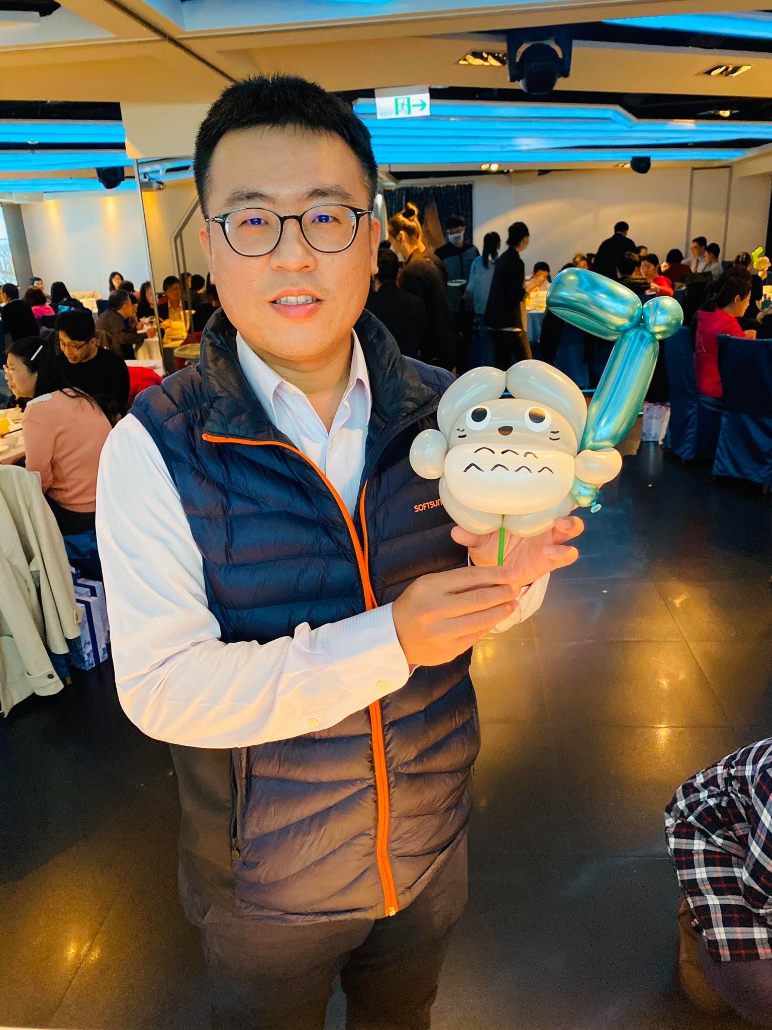 穿深色背心的男賓客拿著灰色龍貓造型手拿棒